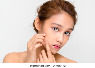 beauty girl of half latina and half asian who checks her skin, skin care, acne treatment