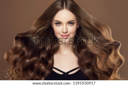Beauty girl with long  and   shiny wavy hair .  Beautiful   woman model with curly hairstyle .