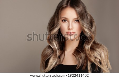 Beauty  girl with long  and   shiny wavy  Hair ,coloring and toning, shatush and balayash .  Beautiful   woman model with curly hairstyle .