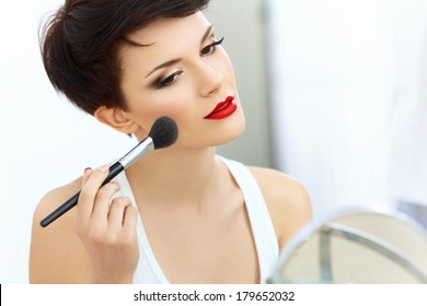Beauty Girl with Makeup Brush. Natural Make-up for Brunette Woman with Red Lips. Beautiful Face. Applying Makeup