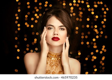 Beauty Girl Makeup. Fashion Jewelry. Elegant Lady In Golden Dress Isolated On Dark With Christmas Party Lights Background. Vogue Style.