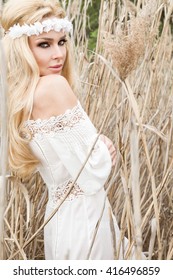 Beauty Girl Outdoors enjoying nature. Beautiful Model girl in white dress running on the Spring Field, Sun Light.