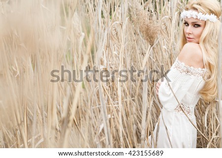 Beauty Girl Outdoors enjoying nature. Beautiful Model girl in white dress running on the Spring Field, Sun Light.
