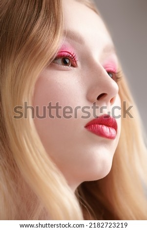 Beauty girl. Portrait of a beautiful blonde girl with soft pink makeup and perfect shiny skin on a white studio background. Beauty care. Make-up and cosmetics. 