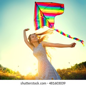 Beauty girl in short dress running with kite on the field. Beautiful young woman with flying colorful kite over clear blue sky. Free, freedom concept. Emotions, healthy lifestyle - Powered by Shutterstock