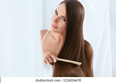 Beauty Hair Care. Beautiful Woman Combing Long Natural Hair