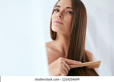 Beauty Hair Care. Beautiful Woman Combing Long Natural Hair