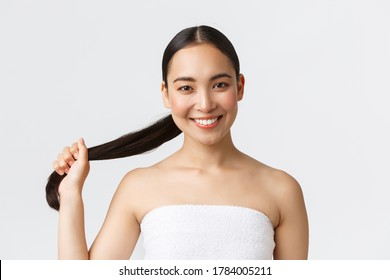 Beauty, Hair Loss Products, Shampoo And Hair Care Concept. Close-up Of Beautiful Asian Woman In Bath Towel Showing Strong And Healthy Hair, Holding Ponytail And Smiling Happy, White Background