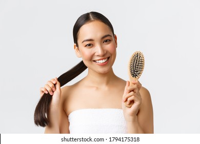 Beauty, Hair Loss Products, Shampoo And Hair Care Concept. Close-up Of Happy Attractive Asian Woman In Bath Towel Showing Brush, Recommend Haircare Product For Healthy Long Hair