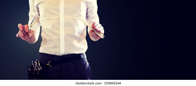 Beauty And Hair Salon, Hairstyle And People Concept - Close Up Of Male Stylist With Scissors And Comb Over Blank Black Background