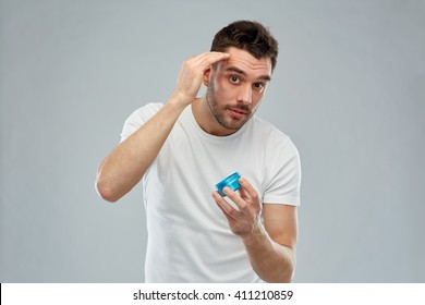 Beauty, Hairstyle, Haircare And People Concept - Happy Young Man Styling His Hair With Wax Or Gel Over Gray Background