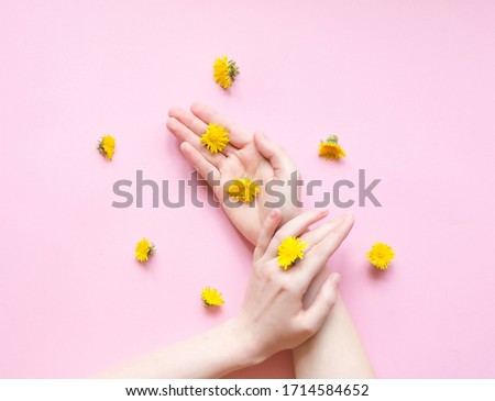 Beauty hands woman and yellow flowers on her hand with makeup. Natural cosmetics product and hand care, moisturizing and wrinkle reduction. Skincare concept.