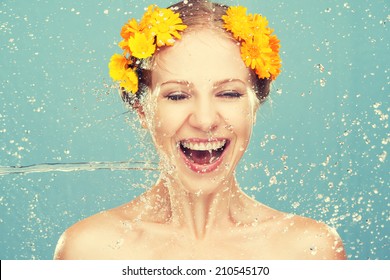 beauty happy laughing girl with splashes of water and yellow flowers