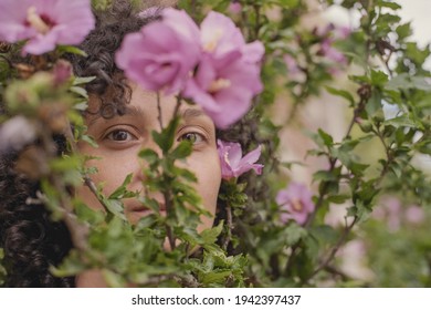 Beauty Headshot Of A Young Brunette Woman With Pink Flowers Outdoors. Shot On 35mm Analog Cine Film.