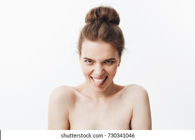 Beauty And Health. Charming Funny European Skinny Woman With Dark Hair In Bun Hairdo Being Naked, Winking, Smiling, Showing Tongue In Camera, Making Funny And Silly Face Expressions.