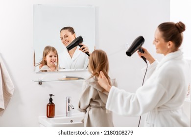 beauty, hygiene, morning and people concept - happy smiling mother and little daughter with hair dryer at bathroom - Powered by Shutterstock