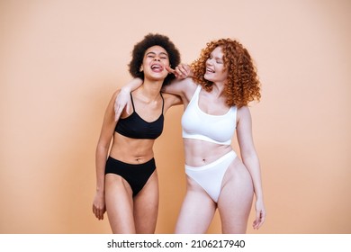 Beauty Image Of Two Young Women With Different Skin And Body Posing In Studio For A Body Positive Photoshooting. Mixed Female Models In Lingerie On Colored Backgrounds