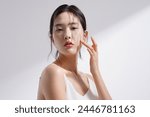 Beauty image of a young Korean woman photographed against a background of light and shadow