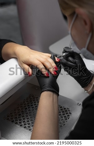 Beauty industry. Manicure salon. Female hands. Self care. Cosmetological gloves. Red nail polish.