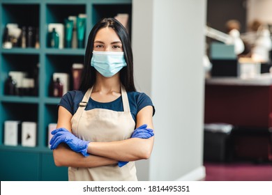 Beauty industry reopening. Professional master in protective mask and gloves standing at hairdresser's interior, empty space