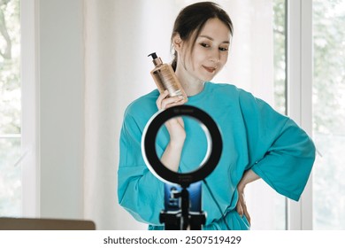 Beauty influencer demonstrating skincare product with ring light setup, content creation, social media marketing, micro-influencer strategy, brand promotion. - Powered by Shutterstock