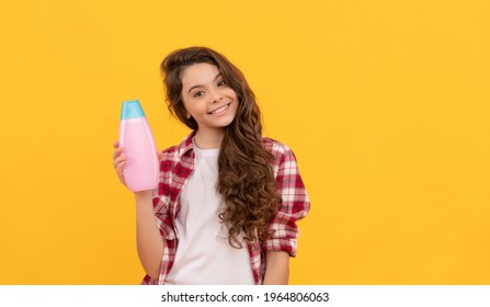 beauty. kid use shower gel. happy teen girl with shampoo bottle. shampooing hair in salon. child with conditioner. long curly hair. daily habits and personal care. presenting cosmetic product.