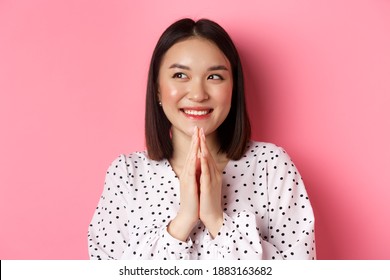 Beauty And Lifestyle Concept. Close-up Of Happy And Satisfied Asian Woman Clap Hands, Expect Something Good, Smiling And Looking Aside, Standing Over Pink Background