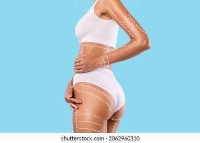 Beauty, Lifting, Anti-age And Tightening Concept. Closeup cropped view of young woman in white top and panties posing with massage lines and arrows on her full body, isolated on blue studio background