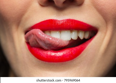 Beauty, Make Up And Mouth Expression Concept - Close Up Of Woman Face With Red Lipstick Licking Her Lips