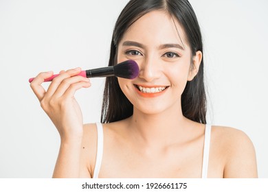 Beauty Makeup Asian Woman Smiling Closeup. Beautiful Young Woman Applying Foundation Powder Or Blush With Makeup Brush. Mixed Race Asian Caucasian Model.