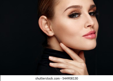 Beauty Makeup. Closeup Of Beautiful Smiling Woman Touching Soft Smooth Facial Skin. Portrait Of Sexy Young Female Model With Professional Make-up And Long Black Eyelashes. Cosmetics. High Resolution