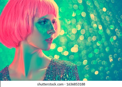 Beauty, makeup and cosmetics concept. Portrait of an attractive girl with shiny glitter freckles and a bright pink wig. Holiday and party style. Copy space. 