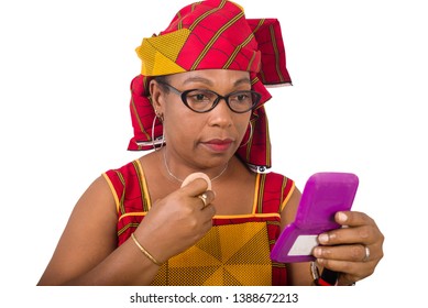 beauty, makeup and elderly concept in red african outfit - senior woman applying powder to face looking in small mirror on white background - Powered by Shutterstock