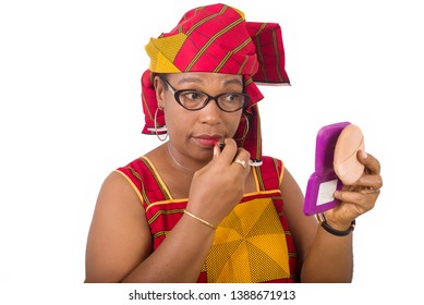 beauty, makeup and elderly people concept in red african outfit - smiling senior woman applying lipstick on her lips looking in small mirror on white background - Powered by Shutterstock