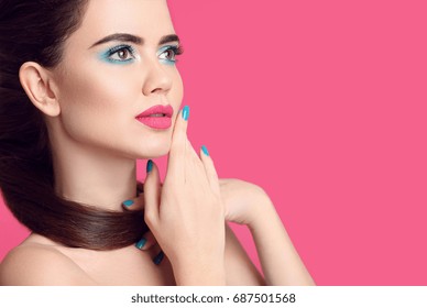 Beauty makeup. Fashion women closeup portrait. Blue manicured nails. Glamour young brunette with eye shadow visage and matte lipstick isolated over pink background.