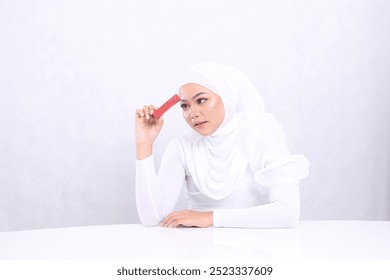 beauty makeup lips adult woman asia hijab beautiful elegant see lipstick hand clamp sideways lipstick container stick forehead isolated white background. cosmetic advertising,lip balm,lipstick mock up - Powered by Shutterstock