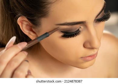 Beauty Makeup. Woman Shaping Eyebrow With Brow Pencil Closeup On A White Background