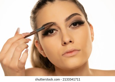 Beauty Makeup. Woman Shaping Eyebrow With Brow Pencil Closeup On A White Background