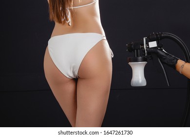 Beauty Master Applying Fake Tan On Woman`s Body. Ekotanning. Ecological Tan. Female Making Tanning In Tan Studio. Client Making An Express Bronzing By Airbrush-pistol.