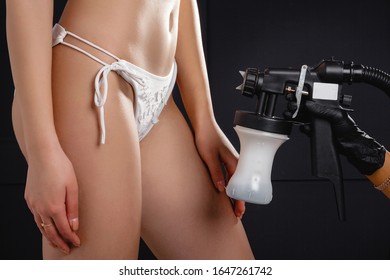 Beauty Master Applying Fake Tan On Woman`s Body. Ekotanning. Ecological Tan. Female Making Tanning In Tan Studio. Client Making An Express Bronzing By Airbrush-pistol.