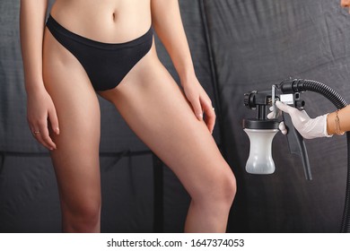 Beauty Master Applying Fake Tan On Woman`s Body. Ekotanning. Ecological Tan. Female Making Tanning In Tan Studio. Client Making An Express Bronzing By Airbrush-pistol.