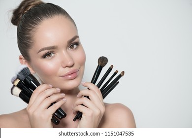 Beauty Model Girl, Makeup Artist Holding Set Of Make Up Brushes And Smiling. Beautiful Brunette Young Woman With Perfect Skin And Nude Make-up. Perfect Skin Closeup. Face Contouring Makeup