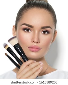 Beauty Model Girl, Makeup Artist Holding Set Of Make Up Brushes. Beautiful Brunette Young Woman With Perfect Skin And Nude Make-up. Perfect Skin Closeup. Face Contouring Makeup. On White Background