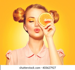 Beauty Model Girl Takes Juicy Oranges. Beautiful Joyful Teen Girl With Freckles, Funny Red Hairstyle And Yellow Makeup. Professional Make Up. Orange Slice 