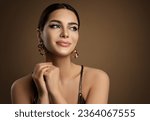 Beauty Model Portrait with plump Lip Makeup looking sideways. Beautiful smiling Woman with smooth Face Skin Make up and Golden Earrings over brown. Dermal Filler