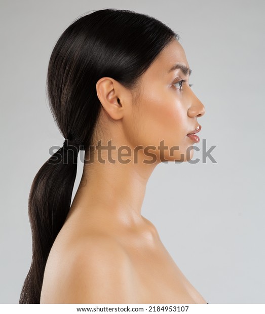 Beauty Model Profile. Young Woman with long\
Ponytail Hair. Women Face Side view over Gray background. Lady with\
Natural Make up and Black Tail\
Hairstyle