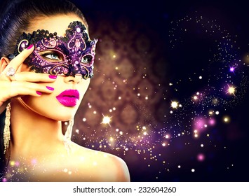 Beauty Model Woman Wearing Venetian Masquerade Carnival Mask At Party Over Holiday Dark Background With Magic Stars. Christmas And New Year Celebration. Glamour Lady