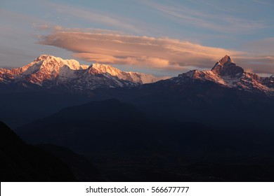Beauty, nature and grandeur. Breathtaking panoramic view of ancient mountain range with snow capped peaks lit with golden evening light at sunset. Annapurna mountains at dusk in fine weather - Powered by Shutterstock