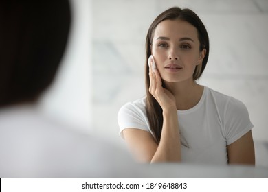 Beauty needs care. Pretty young lady doing daily morning skincare procedures, cleansing face skin with natural lotion tonic using cotton disc sponge pad, removing makeup by micellar water at evening - Shutterstock ID 1849648843