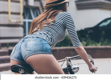 Beauty On Bike.  Rear View Of Beautiful Young Woman With Perfect Buttocks Riding Bicycle Along The Street 